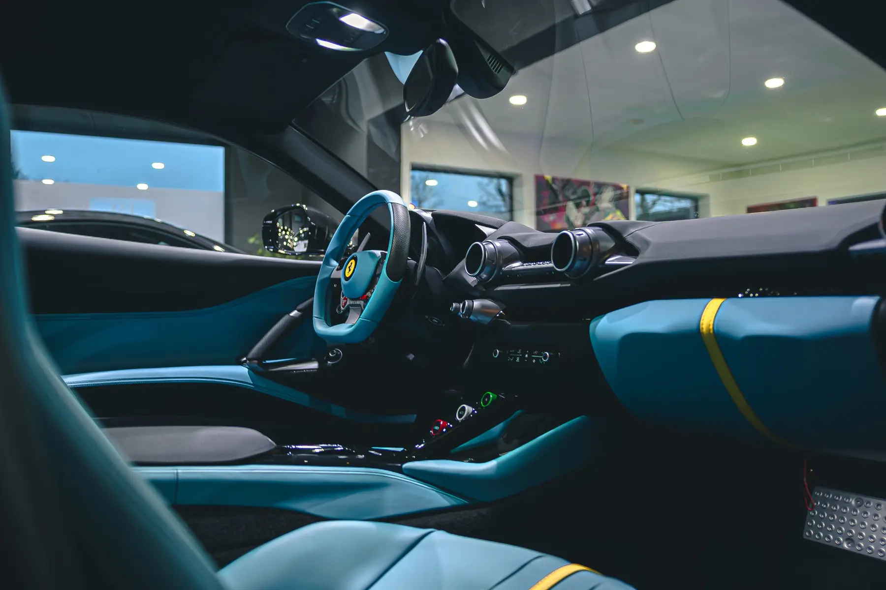 Ferrari cockpit with light blue leather, view through the windshield into the showroom