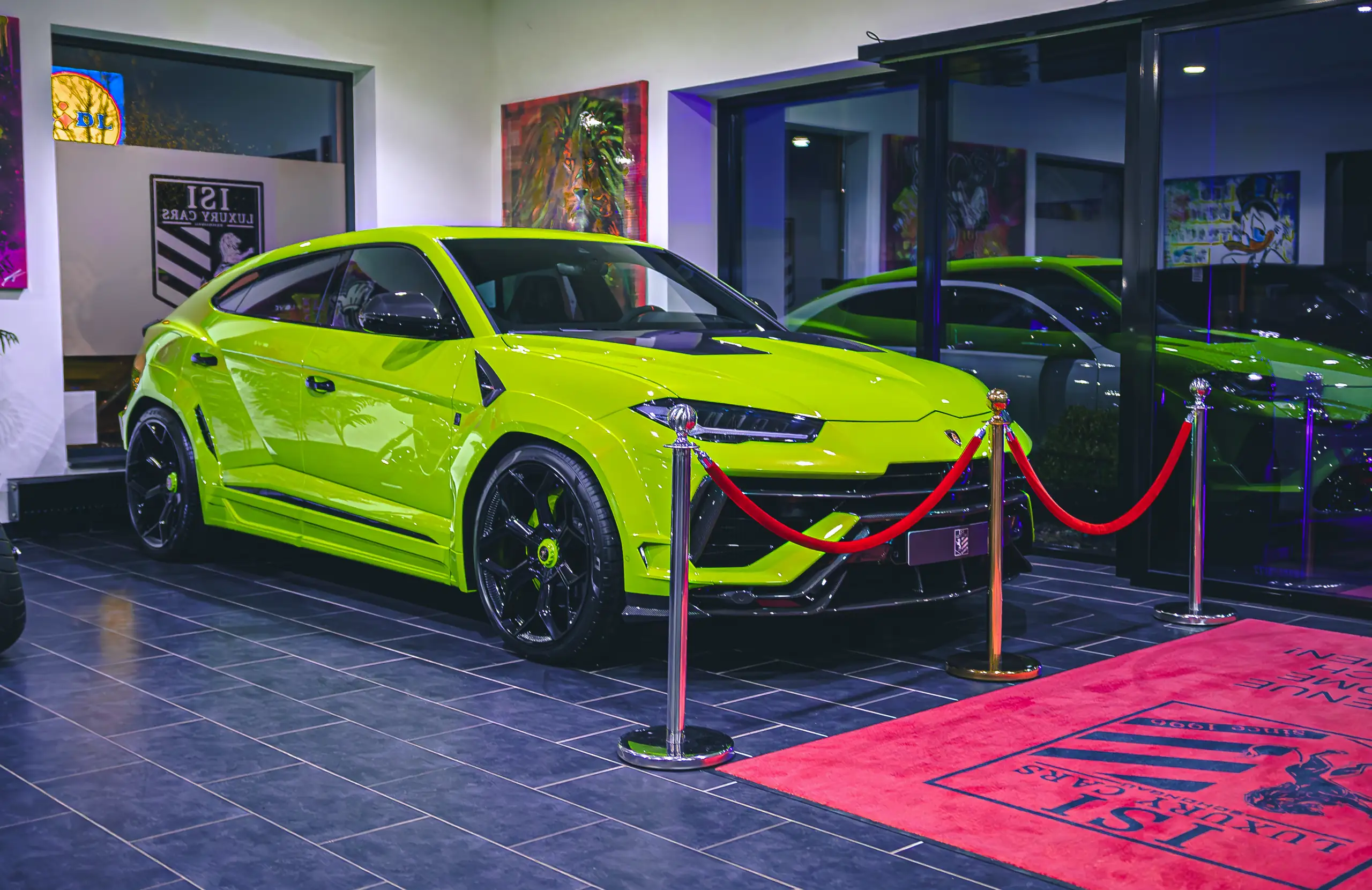 Lamborghini Urus in Limettengrün hinter roten Kordeln, daneben der rote Teppich mit dem ISI-Wappen