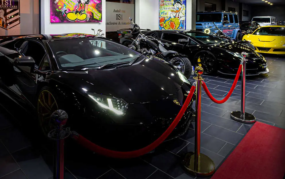 Dark sports cars in the showroom, pop-art pieces on the walls