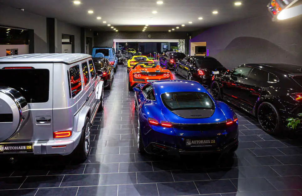 View along the vehicle lineup in the showroom, a white Mercedes G-Class in front
