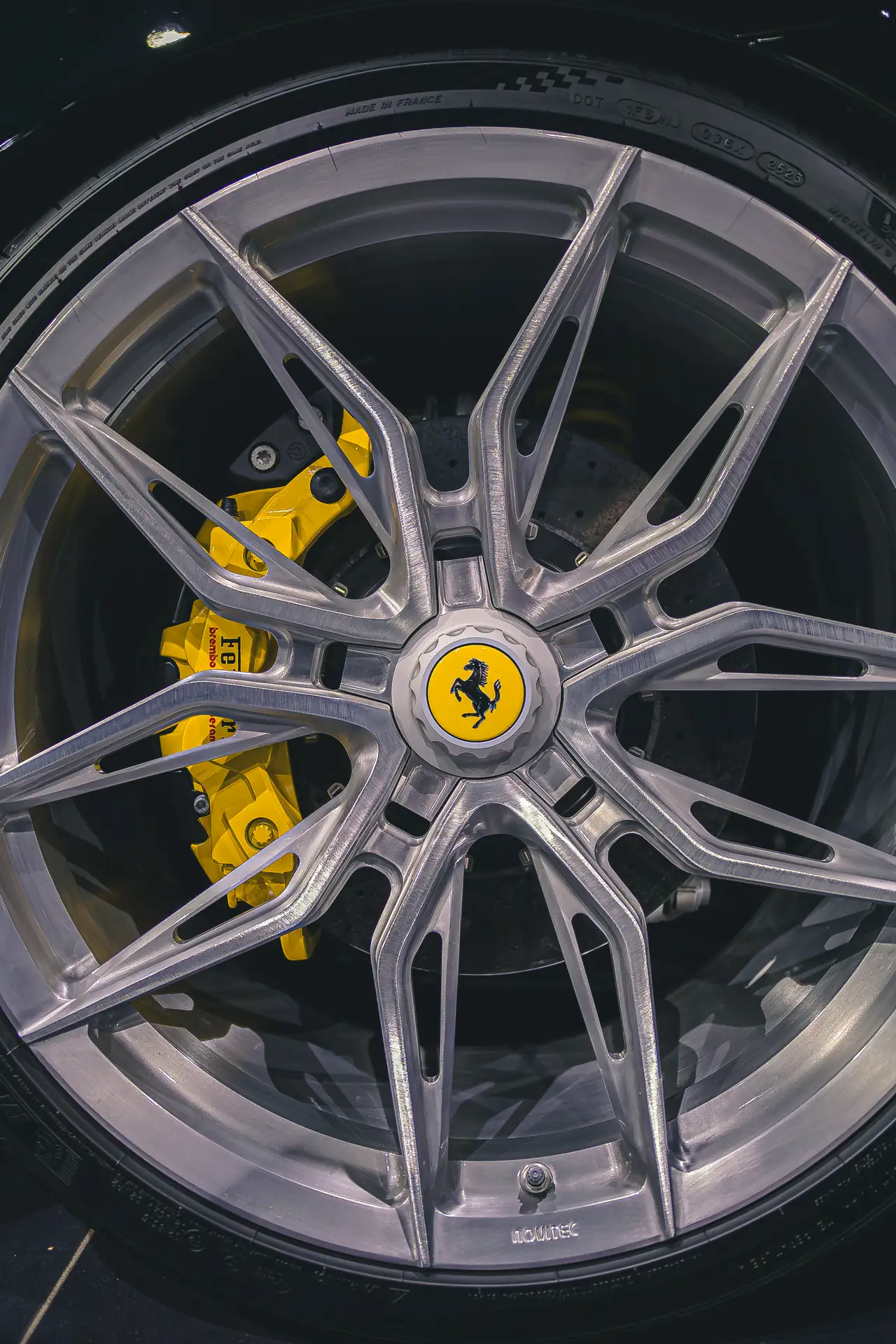 Rad eines Ferrari mit gelber Bremszange im Showroom von Autohaus ISI
