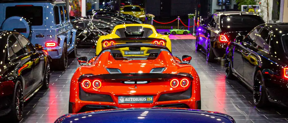 Rear view of several sports cars side by side, a red Ferrari with an Autohaus ISI license plate frame in front