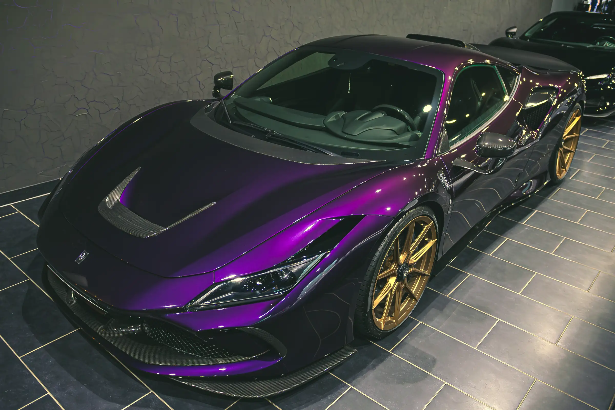 Violetter Ferrari mit goldenen Felgen im Showroom von Autohaus ISI